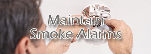Maintain Smoke Alarm - Man adjusting smoke alarm